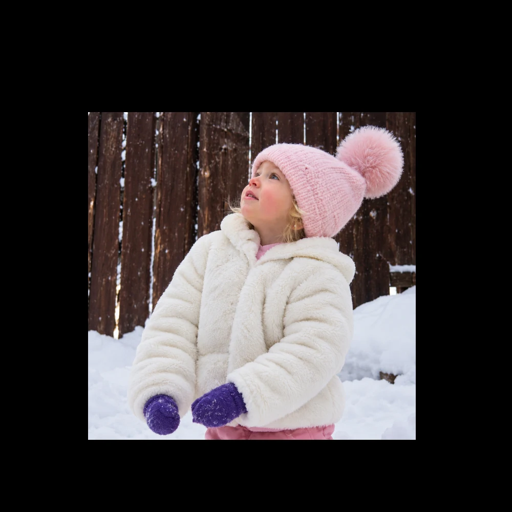 A little girl in a pink hat, shown inside a round MemoryOrb lens
